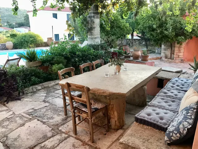 Stenen tafel op het terras onder de wijnranken — Spiti Athinà, Gavalochori, Kreta