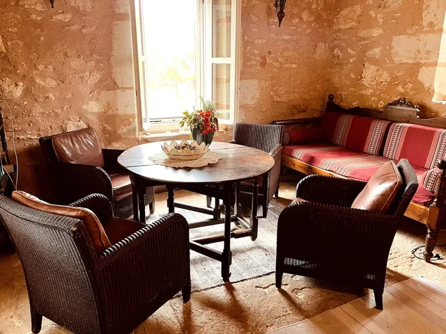 Gezellige zithoek met lederen fauteuils en stenen muren — Spiti Athinà, Gavalochori, Kreta