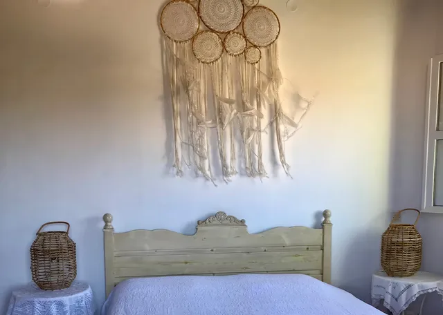 Hoofdslaapkamer detail met dromenvangermuurdecoratie — Spiti Athinà, Gavalochori, Kreta